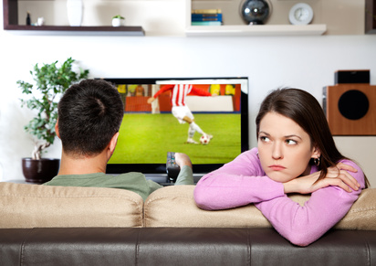Gelangweilte Frau beim Fußballabend