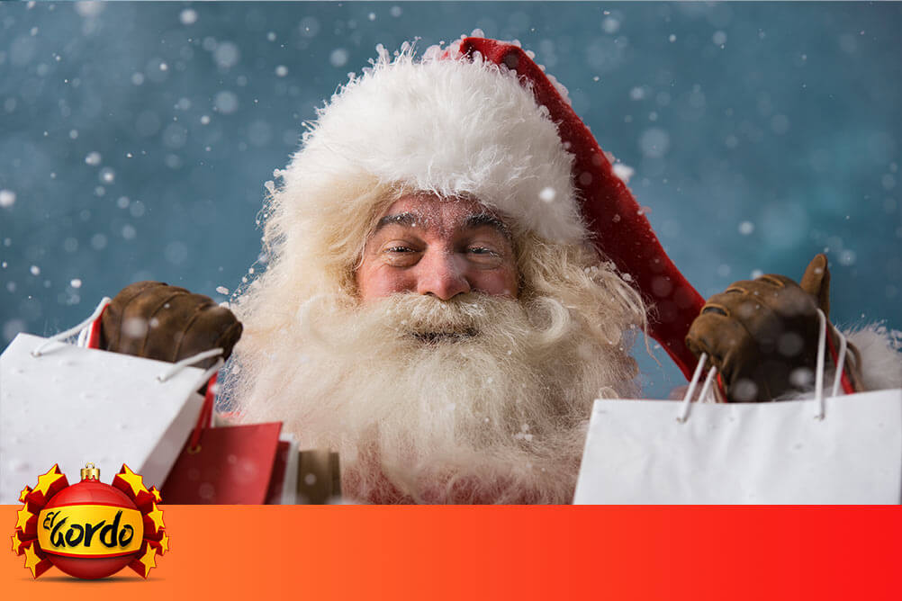 Vom Megalos zum Glückslos - Milliarden bei El Gordo zu gewinnen Lächelnder Weihnachtsmann mit Geschenktüten