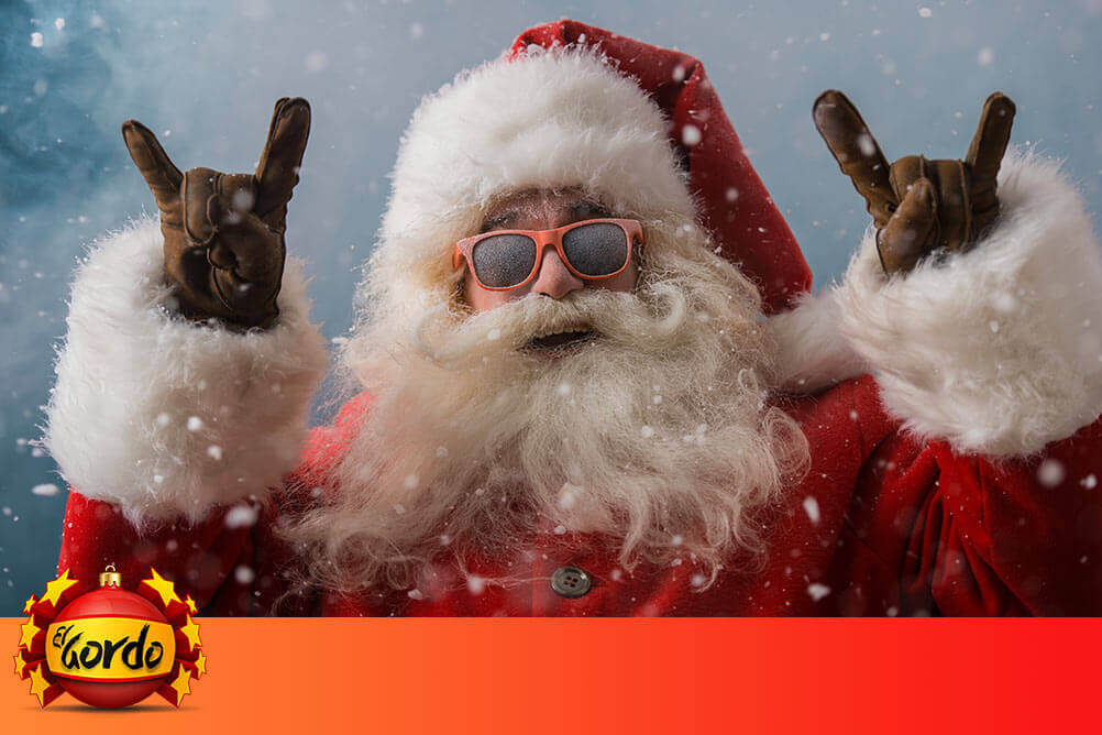 Weihnachtsmann mit Sonnenbrille macht Rock-it-Zeichen mit beiden Händen