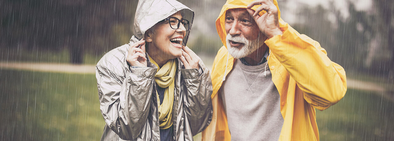 Zwei Menschen lachen glücklich im Regen