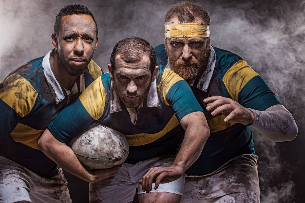 Der Lottoland Rugby Wettguide Bild zeigt drei Rugby Spieler, die in die Kamera schauen und hoffen, dass du durch den Lottoland Rugby Guide auf das richtige Team wettest.