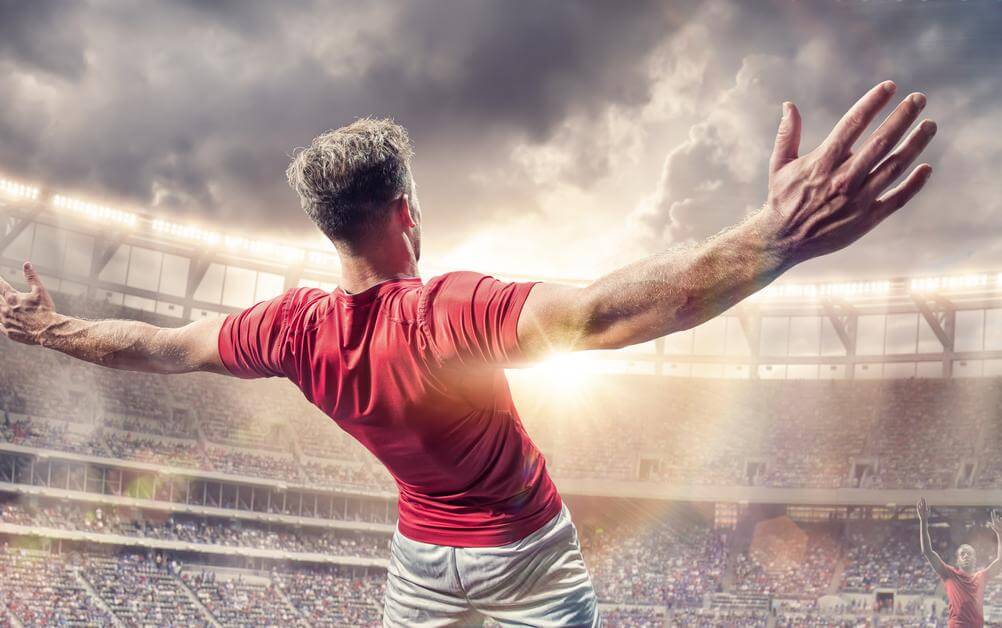 „Beide Teams treffen“ (BTTS) – Torjubel auf dem Spielfeld Ein Fußballspieler im roten Trikot jubelt mit dem Rücken zur Kamera nach einem Tor – perfekte Szene für alle, die auf „Beide Teams treffen“ (BTTS) gewettet haben.