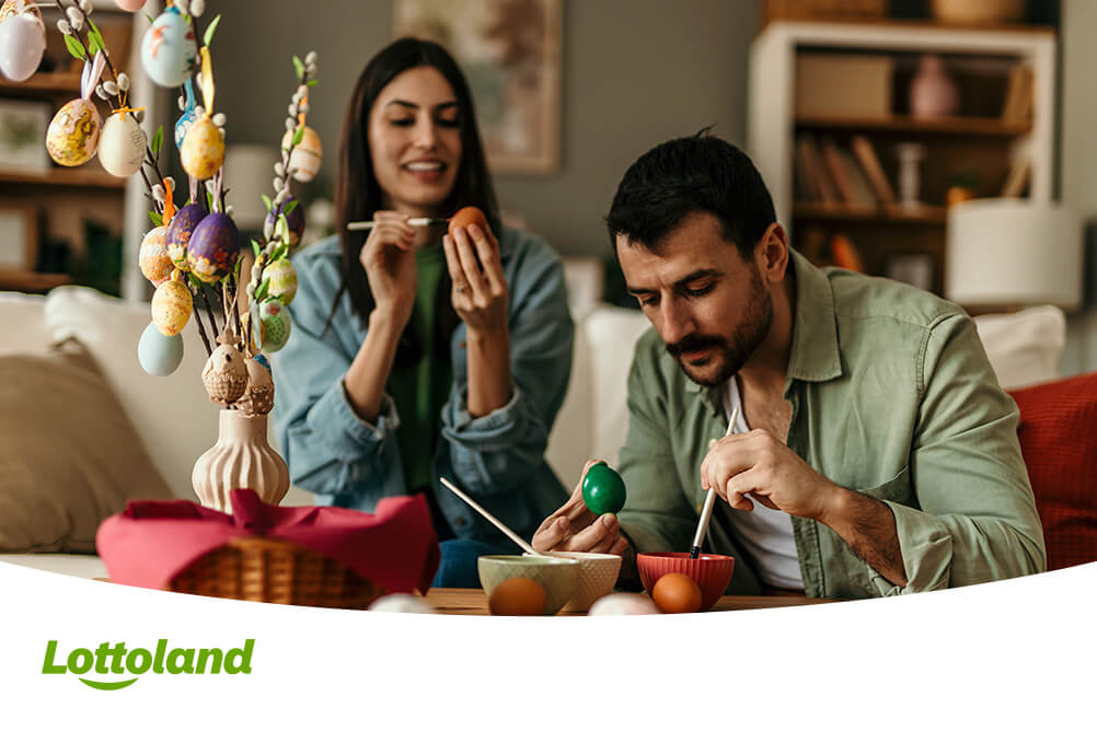 Ein Paar folgt dem deutschen Osterbrauch und bemalt Ostereier zu Hause.